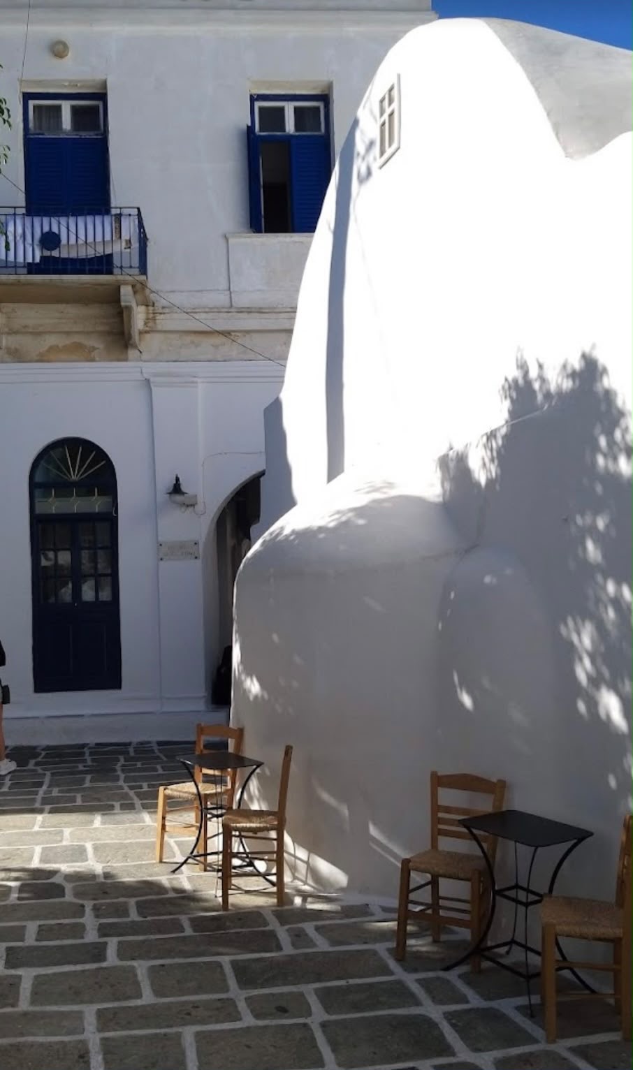 La petite chapelle blanche et les tables à l'ombre